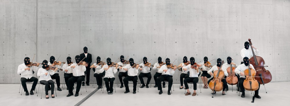 A string orchestra with 20 people. All musicians are wearing white shirt and black balaclava covering their face.
