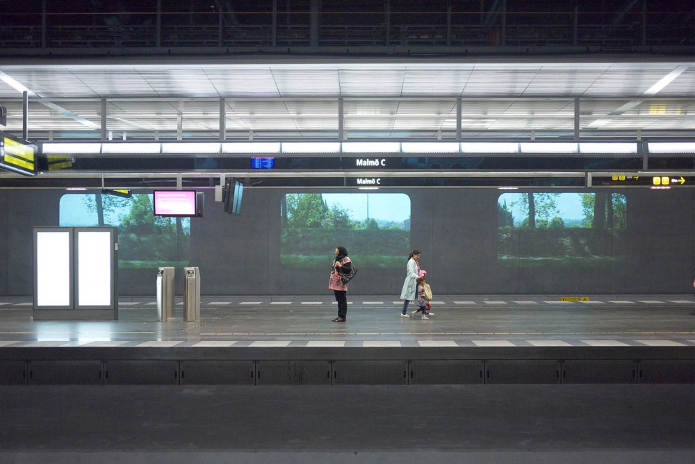 Two people on a platform. In the bakground three projections.