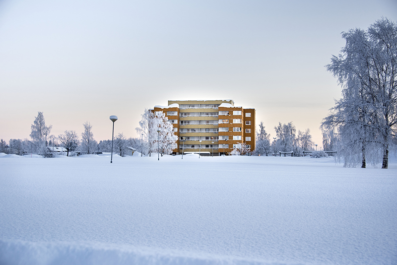 High-rise building on distance in a landscape covered with snow.