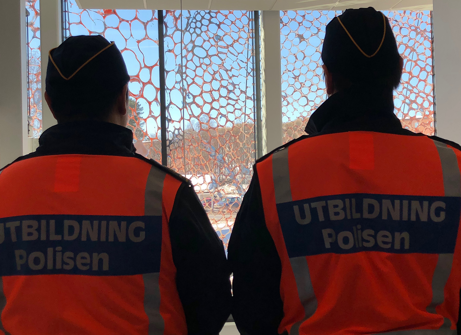 Two people with orange vests are looking at the artwork from the inside.