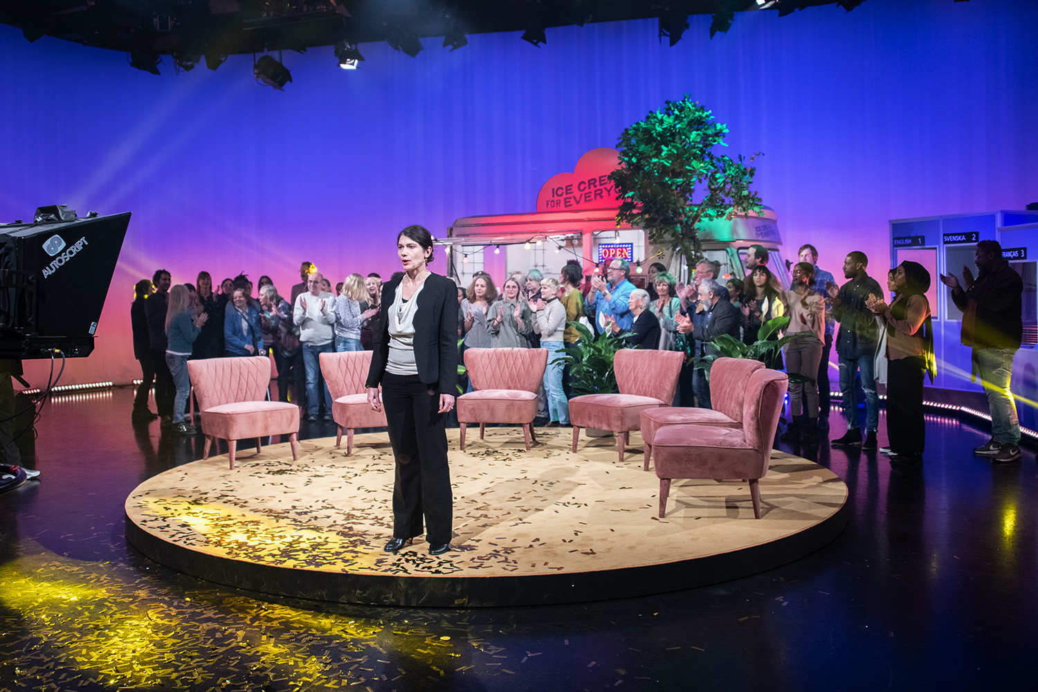 Audience in a TV-studio with a woman in the front.