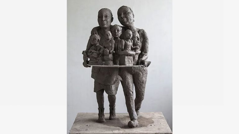 En skulptur av lera av två unga kvinnor som bär fram byster på fem kvinnor.