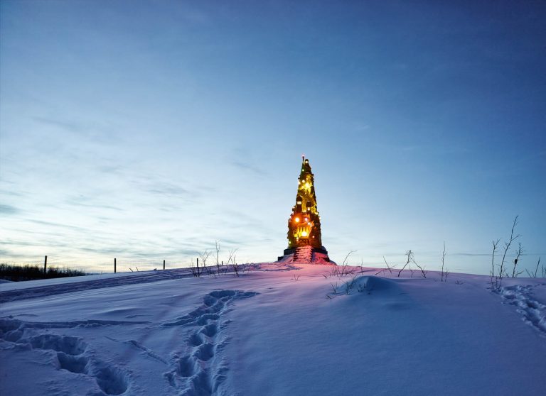 I ett snötäckt landskap lyser skulpturenen Totem av Oskar Aglert i olika färger.