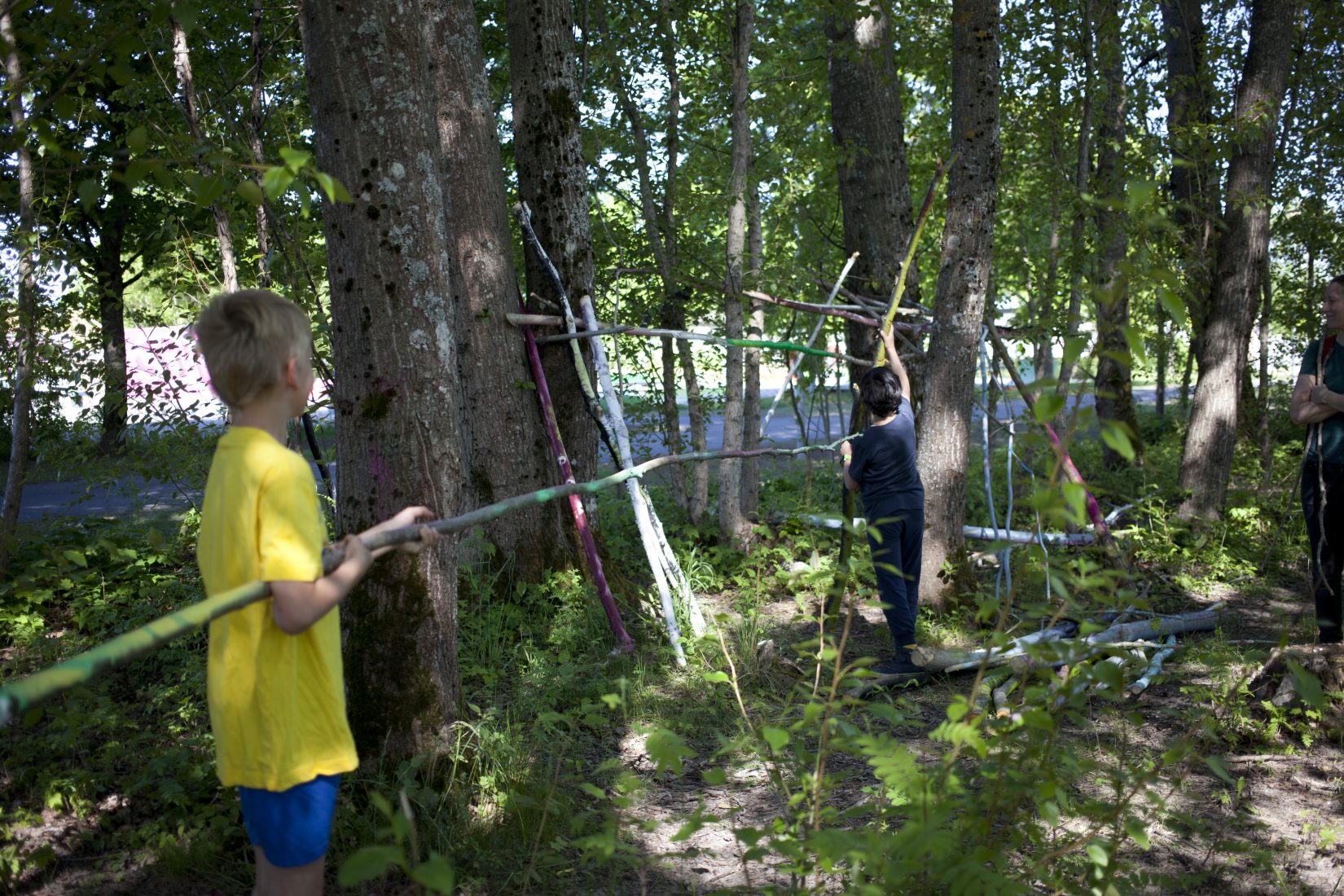 Barn bygger med pinnar i skogen