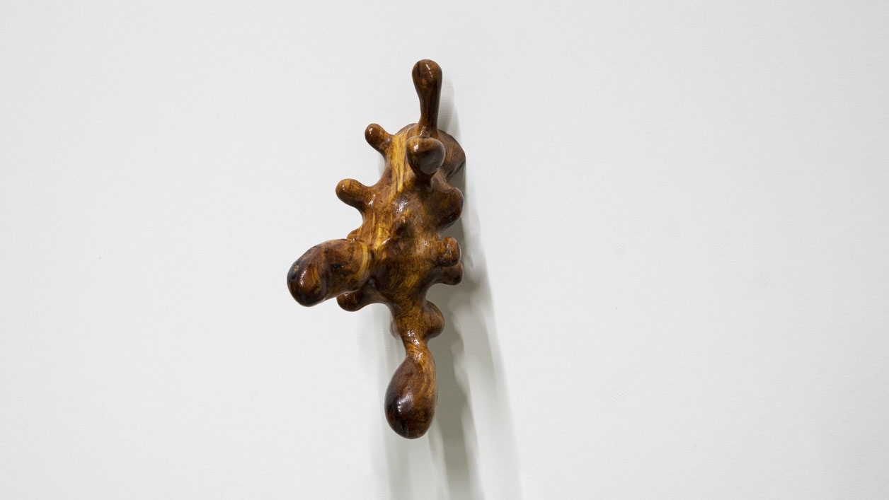 En träskulptur som sitter fast på en vägg